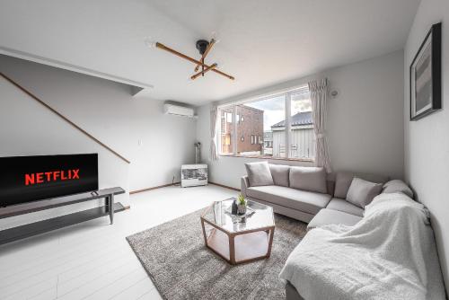a living room with a couch and a tv at Hills Niseko B in Niseko