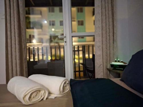a room with a bed and a window with towels at Casa Aurora in Mandaue City