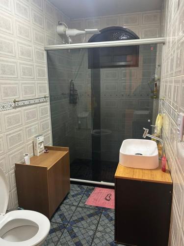 a bathroom with a shower and a toilet and a sink at Refúgio ao mar in Rio das Ostras