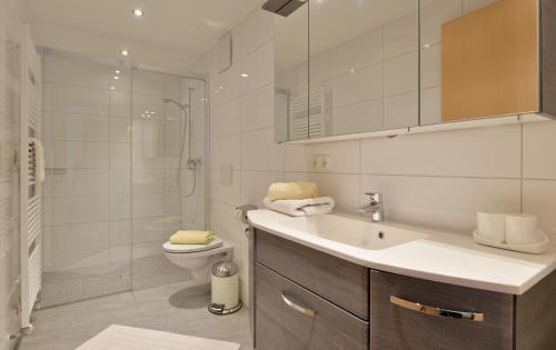 a bathroom with a sink and a toilet and a shower at Gasthof Appartement`s Staffnerhof in Kössen