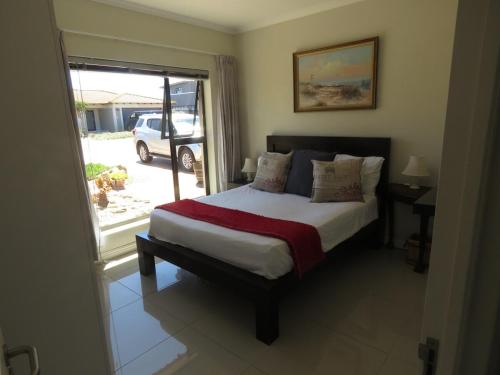 a bedroom with a bed and a window at the range in Langebaan