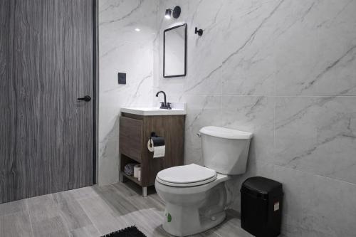 a bathroom with a toilet and a sink and a mirror at Depto Tec by tuhost in Monterrey