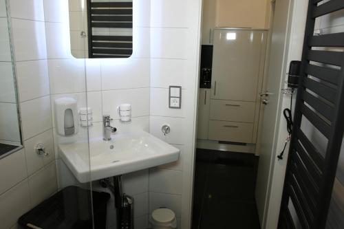a white bathroom with a sink and a mirror at Vlotho Apartment in Vlotho