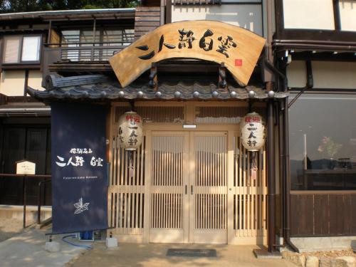 a building with a sign on the front of it at Hidatakayama Futarishizuka Hakuun in Takayama
