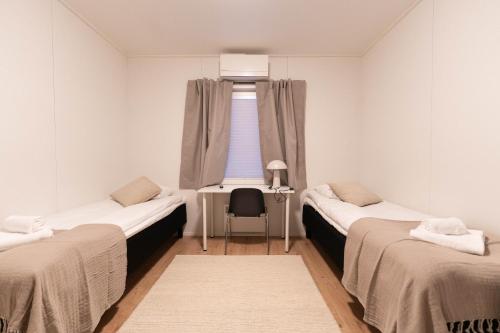 two beds in a room with a window at LODGE Hostel Ylläs in Äkäslompolo