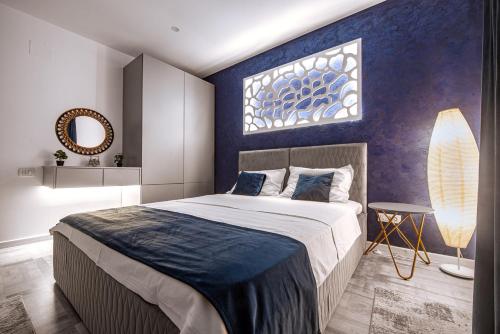 a bedroom with a large bed with a blue wall at Vila H2O in Mangalia