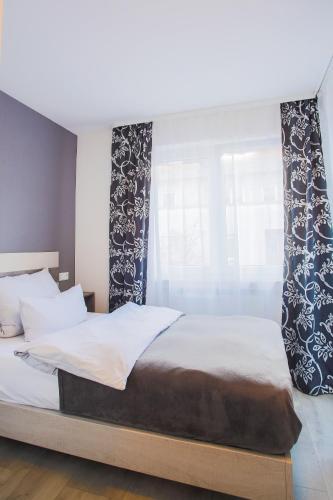 a bedroom with a bed and a window at City Vibes Hotel in Sindelfingen