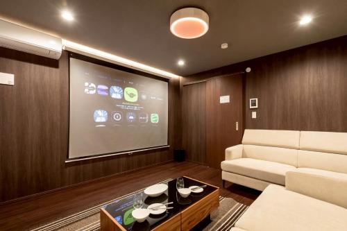a living room with a couch and a large screen at J-BASE BRICKS Osaka Imazato in Osaka