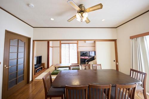 a dining room with a ceiling fan and a table at TSUMUGI 紡 ー Garden Villa in Nagano in Nagano