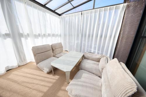 a living room with a couch and a table at TSUMUGI 紡 ー Garden Villa in Nagano in Nagano