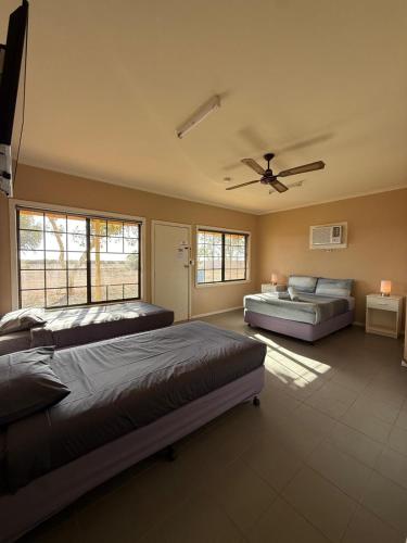a bedroom with two beds and a ceiling fan at Cadney Park Accommodation in Coober Pedy