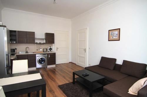 a living room with a couch and a kitchen at KV Apartmány Sokolovská in Karlovy Vary
