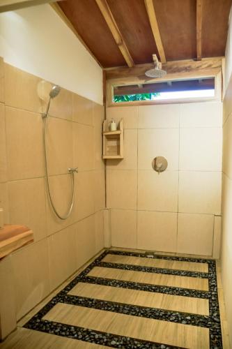 a bathroom with a shower and a tile floor at Beda gaya ecolodge Rangsot 1 in Tanjung