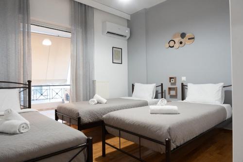 a room with three beds and a window at Acropolis luxury home in Athens