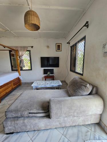 a living room with a couch and a tv at Casalola in Mombasa