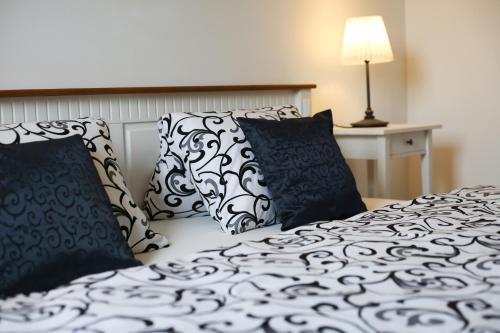 a bedroom with two beds with black and white pillows at Penzion Recall in Troskovice