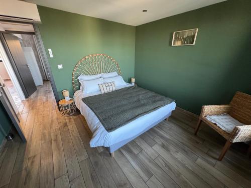 a bedroom with a bed and a green wall at Lodges des Pontons - Cap Ouest - vue mer in Saint-Côme-de-Fresné