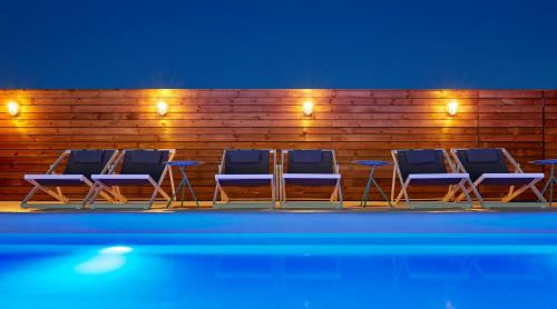 a group of blue chairs sitting next to a wooden fence at Delamar 4*Sup-Adults only (18+) in Lloret de Mar