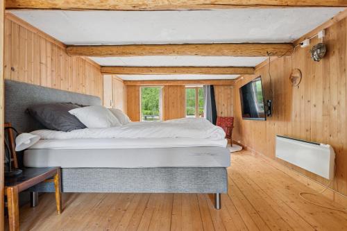 a bedroom with a large bed in a room with wooden walls at Brygge Sjøgata in Mosjøen