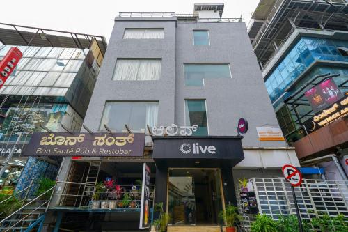 a tall building with a live store in a city at Olive Zip Rest House Road by Embassy Group in Bangalore