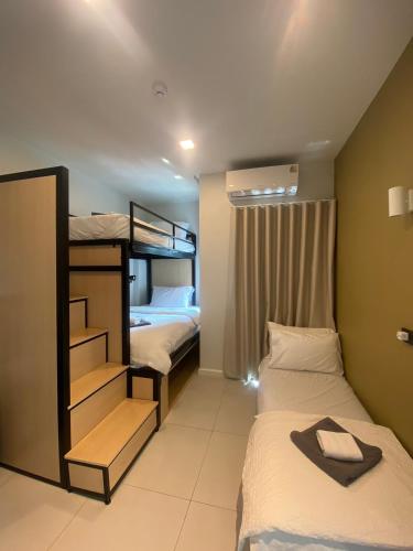 a bedroom with two beds and a bunk bed at Airport one station hometel - Suvarnabhumi - SHA Extra Plus in Bangkok
