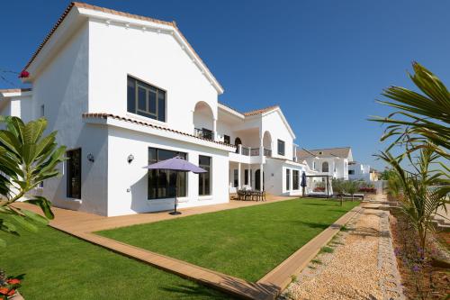 a white house with a large yard at Maison Privee - Villa on Beach with Private Pool The Palm Jumeirah in Dubai