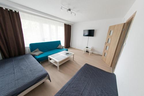 uma sala de estar com um sofá azul e uma mesa em Apartament pracowniczy em Stalowa Wola