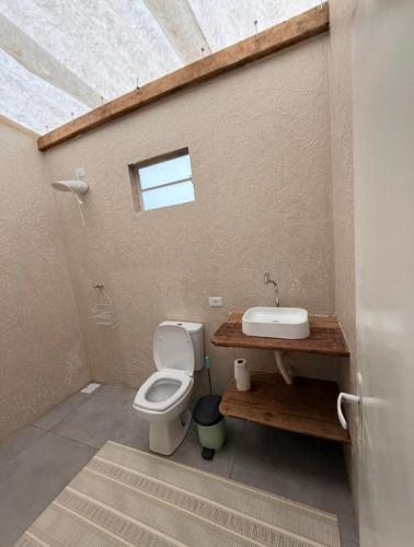a bathroom with a toilet and a sink at Hostel Sideral in Campo Grande