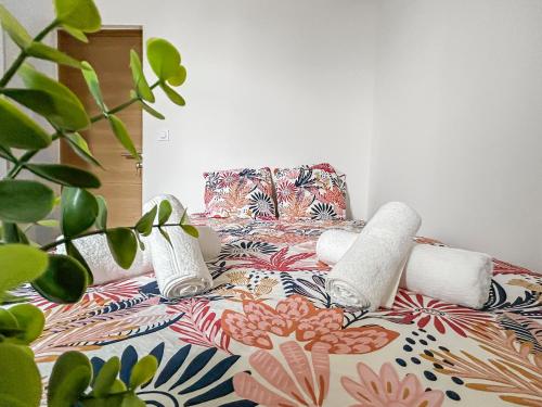 a bed with pillows and a chair with a plant at Appartement moderne et lumineux avec parking privé in Vierzon