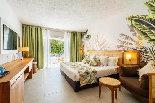 a hotel room with a bed and a couch at Casuarina Resort and Spa in Trou aux Biches