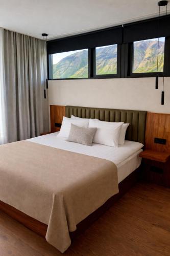 a bedroom with a large bed with a large window at Hvanndalir Lodge in Ólafsfjörður