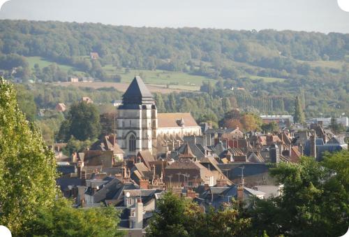 a small town with a tower and a town with houses at Eden Park Hotel Restaurant in Pont-lʼÉvêque