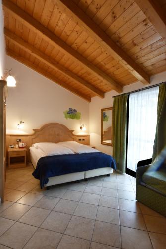 a bedroom with a bed and a large window at Agritur Campo Fiorito in Dro