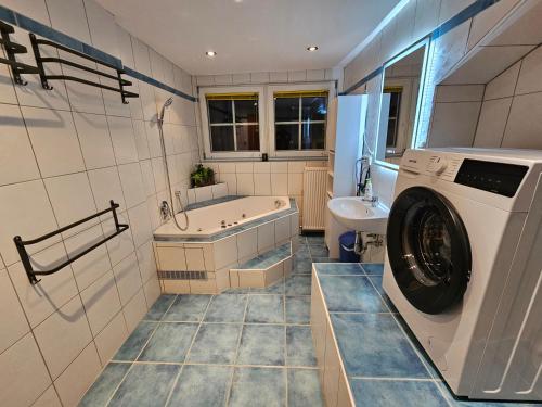 a bathroom with a washing machine and a sink at Ferienwohnung Bergherz in Sankt Johann im Walde
