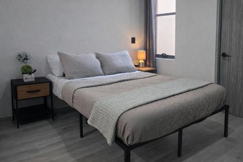 a bedroom with a large bed with a nightstand and a bed sidx sidx sidx at Depto Tec by tuhost in Monterrey