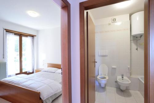 una camera con letto, servizi igienici e lavandino di Apart Erica a Comano Terme