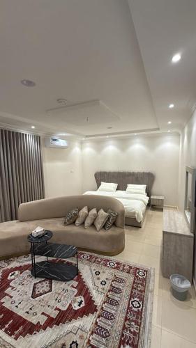 a living room with a couch and a bed at شقق وغرف خاصة الشفاء in Hail