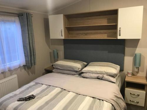 a bed with pillows on it in a bedroom at Moray Coast getaway in Lossiemouth