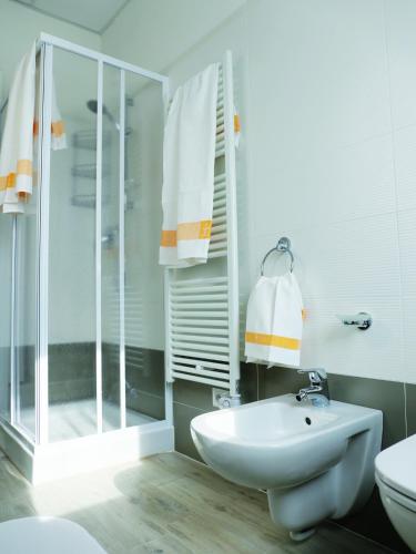a white bathroom with a shower and a sink at Residenze Parmensi in Castelguelfo