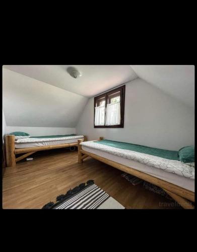 a room with two beds and a window at Csobogó Patak Vendégház in Sicasău