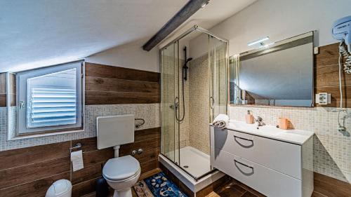 a bathroom with a toilet and a shower and a sink at Apartman Roza 2 by Villas Guide in Vela Luka