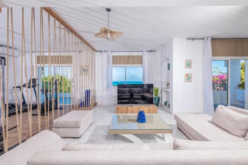a living room with a couch and a table at Villa Verde Azura in Bin Rhilouf