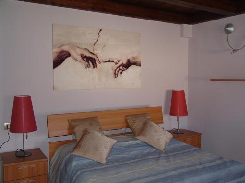 イグレージアスにあるSu Bellixedduのベッドルーム1室(ランプ2つ、壁に絵画付)