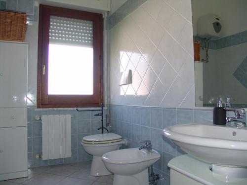 bagno con lavandino, servizi igienici e finestra di Su Bellixeddu a Iglesias