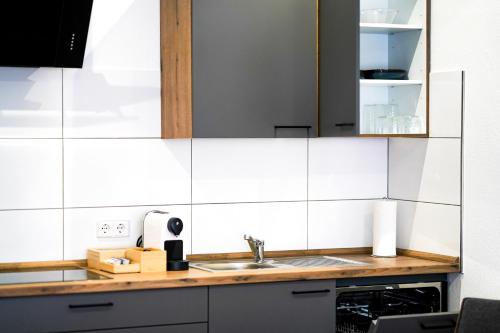 a kitchen counter with a sink and a mirror at Apart4me Style Apartment Geislingen zentral mit Parkplatz in Geislingen an der Steige