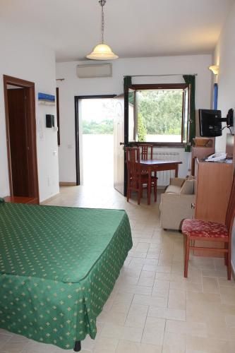 a living room with a green bed and a dining room at Il Casaletto Dei Ludi in Aranova