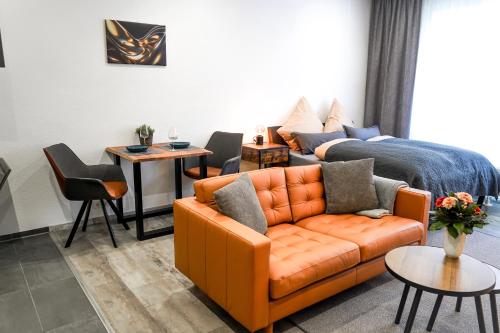 a living room with a couch and a bed at Apart4me Style Apartment Geislingen zentral mit Parkplatz in Geislingen an der Steige