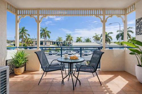 a balcony with a table and chairs and a view of a street at Waterfront Apartment Near City, Stadium & Ferry Townsville in Townsville
