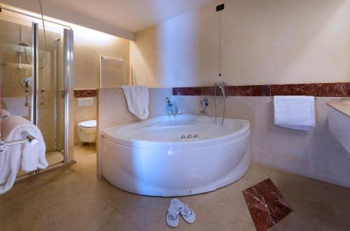 a bath room with a tub and a sink at CDH Hotel Radda in Radda in Chianti