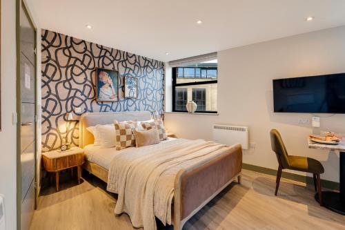 a bedroom with a large bed and a tv at Your Apartment I Clifton Village in Bristol